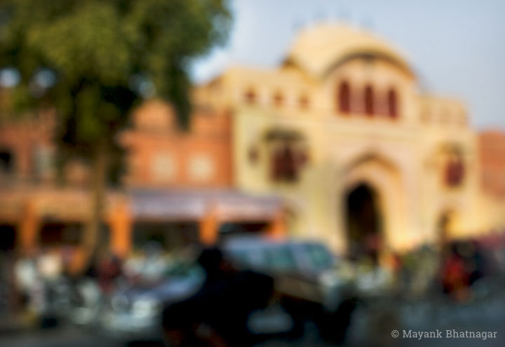Soft focus photograph of road traffic moving in front of iconic architecture in the Jaipur walled city