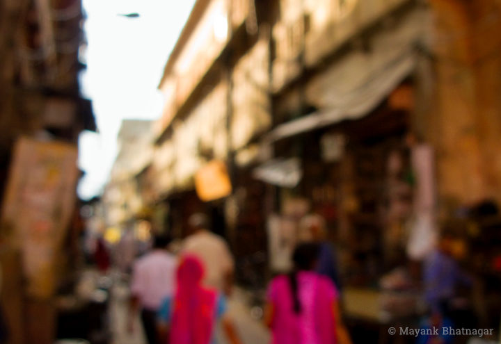 People walking in a narrow lane of Jaipur Pink City with old architecture and some shops