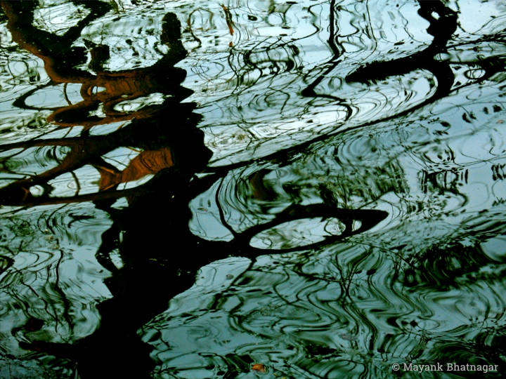 Abstract photograph of water resembling a watercolour painting, in dominant cyan and black colours