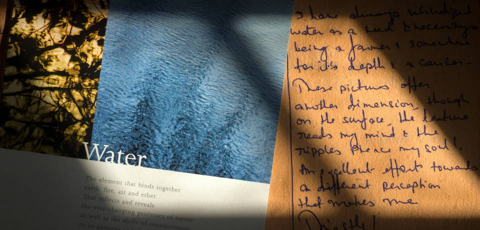 Light falling on a photography show brochure and comments diary with a review handwritten on it