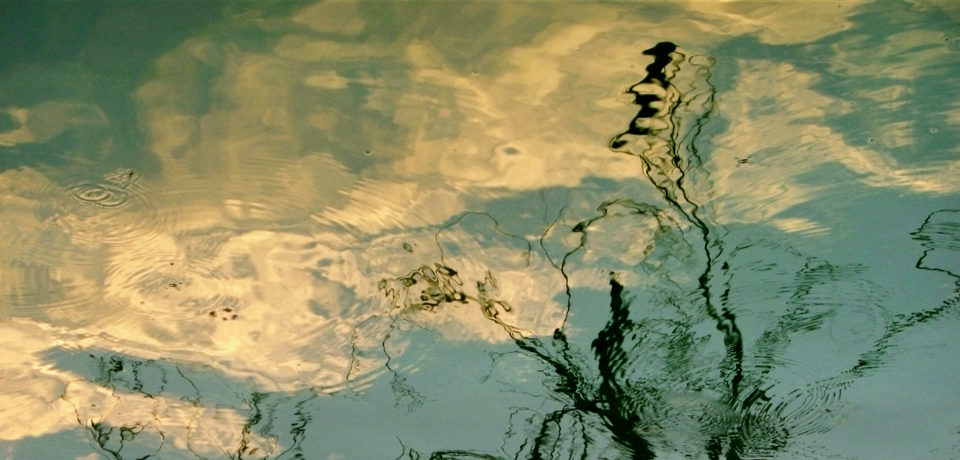 Fine art photograph of rhythmic reflections of clouds and trees on the surface water, resembling a painting