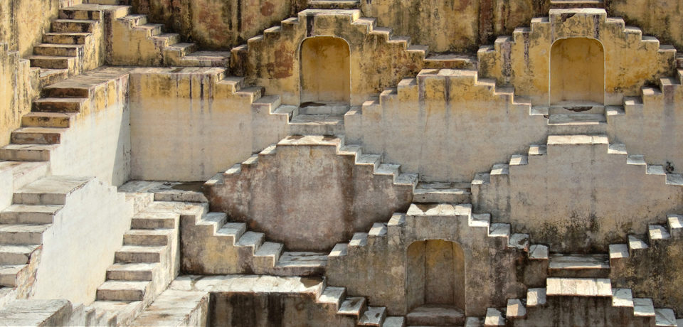 Tight shot of an old stepwell, showing many identical stairs connecting at different levels
